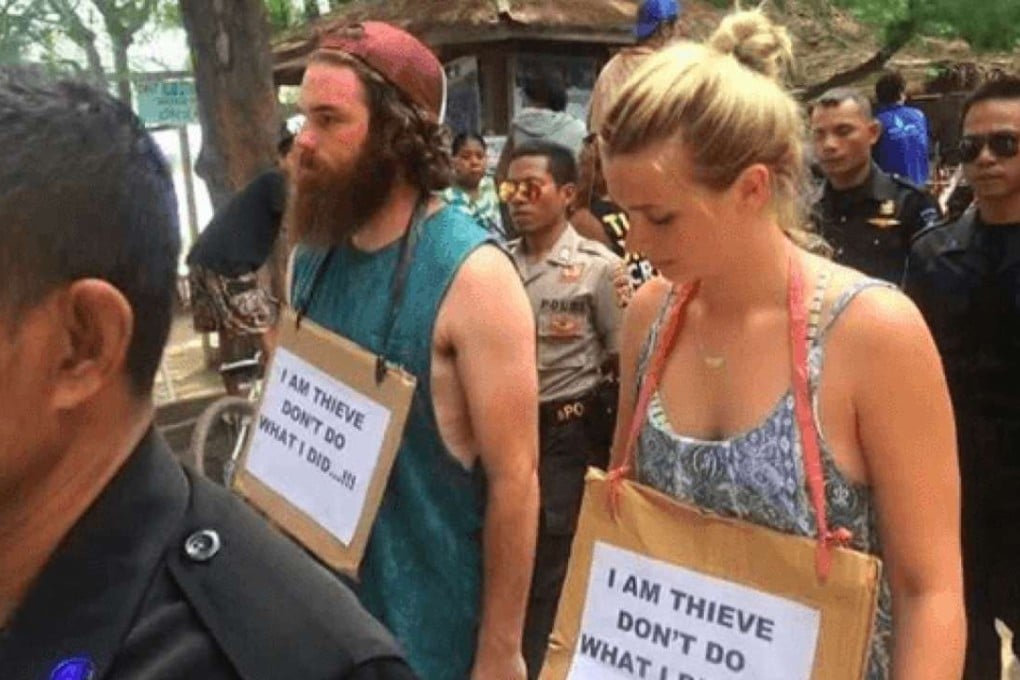 An Australian man and woman accused of stealing a bicycle have been paraded through the streets of an Indonesian island with signs around their necks warning others against theft. Photo: Instagram