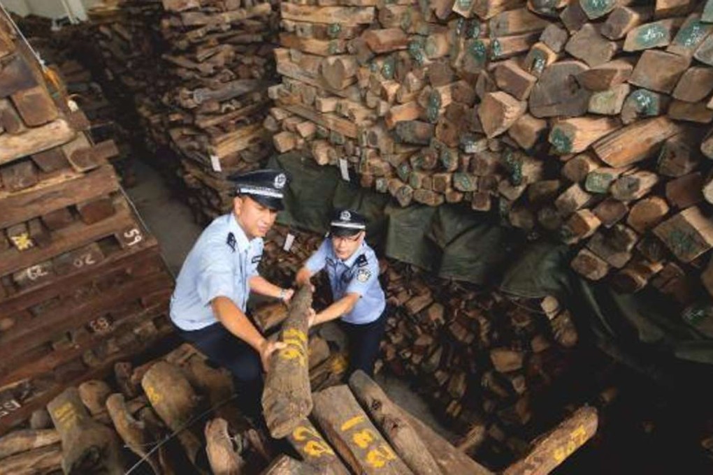 Customs officials in Guangzhou check seized hardwood timber worth an estimated 1.05 billion yuan, in 2014. Photo: Cites Secretariat