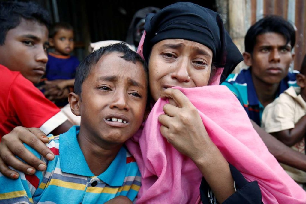 A Rohingya Muslim woman and her son cry after being caught by Border Guard Bangladesh while illegally crossing at a border check point in Cox’s Bazar. Photo: Reuters