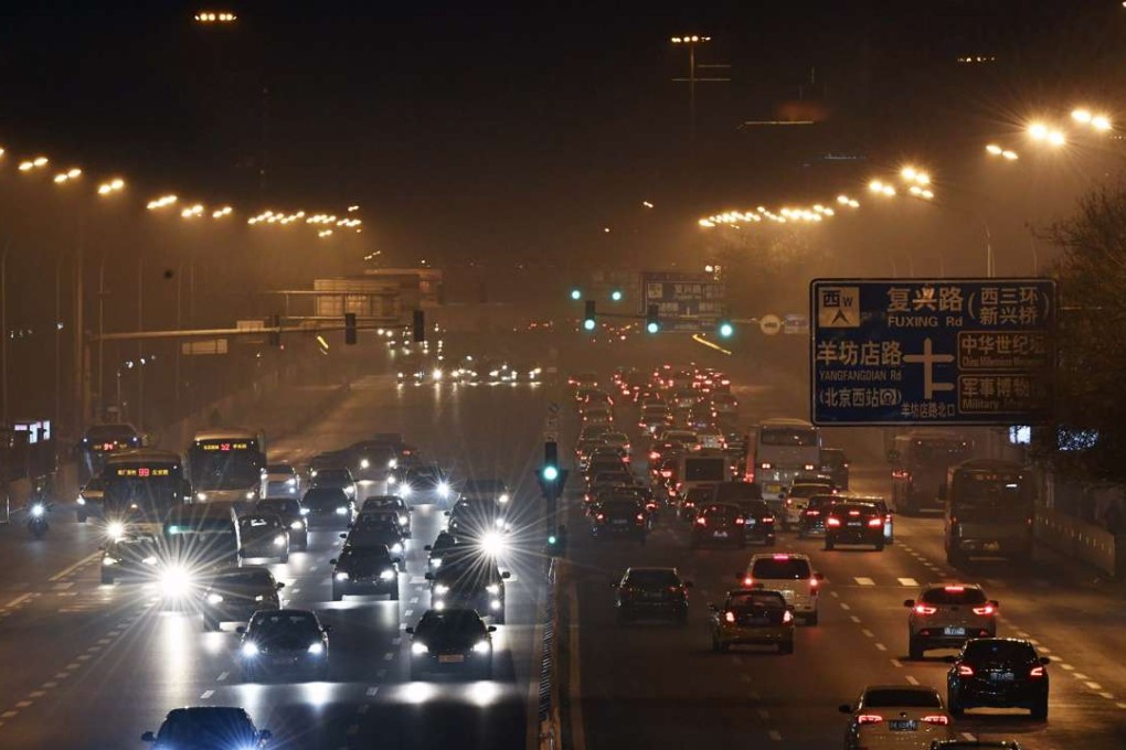 Cars move on a road blanketed in smog in Beijing on Friday, when the capital city activated its first red alert for air pollution this year. Photo: Xinhua