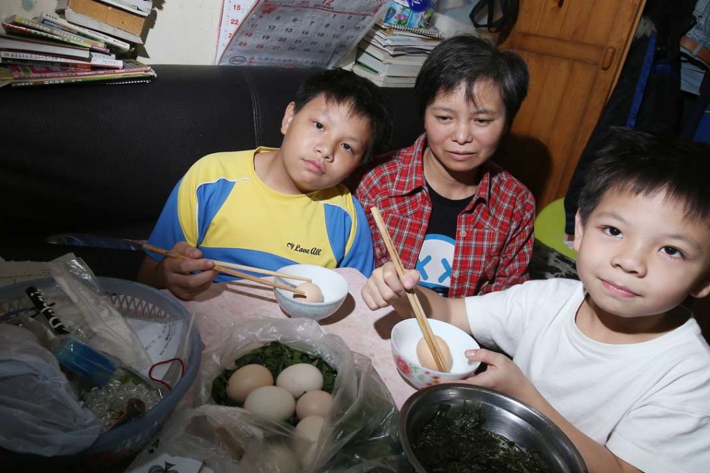 Li Ching-wan, 12; his mother Li Yan-ling; and his brother Tang Chung-kai, 9, at home in Sham Shui Po. Photo: David Wong