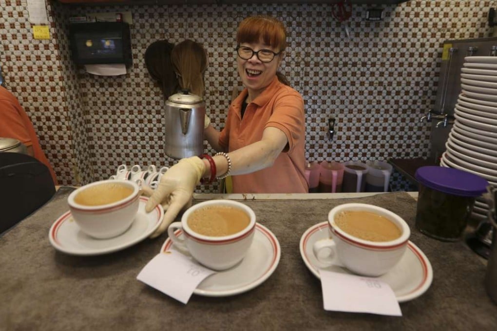 A woman serves up milk tea at a cha chaan teng in Happy Valley. Photo: Nora Tam