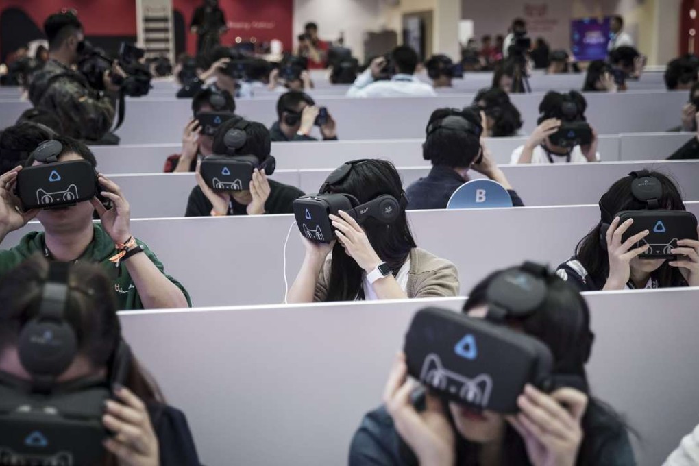 Members of the media wear virtual reality headsets featuring the Tmall Cat, mascot for Alibaba Group Holding Ltd.'s Tmall online marketplace, at Alibaba's annual November 11 Singles' Day online shopping event in Shenzhen. Photo: Bloomberg