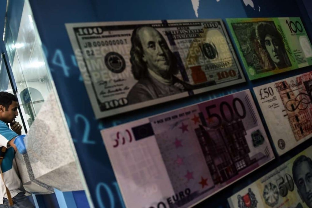 A foreign tourist inquires about exchange rates on the Malaysian ringgit at a foreign currency money-changer in Kuala Lumpur. The currency on Tuesday hovered near its lowest level since the height of the 1998 Asian Financial Crisis. Photo: AFP Photo