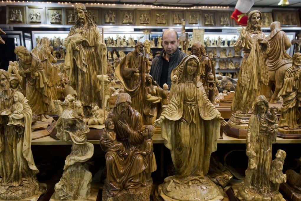 A shopkeeper walks through a souvenir shop in the West Bank city of Bethlehem. Many souvenirs, including the West Bank town’s trademark rosemary beads, are imported from abroad, mainly China. Photo: AP