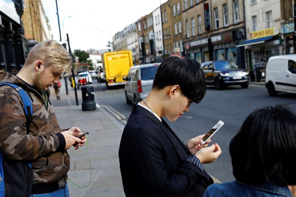 Pedestrians in London looking at their smartphones. Chinese technology start-ups are increasingly aiming to make their products more appealing to a global audience. Photo: Reuters