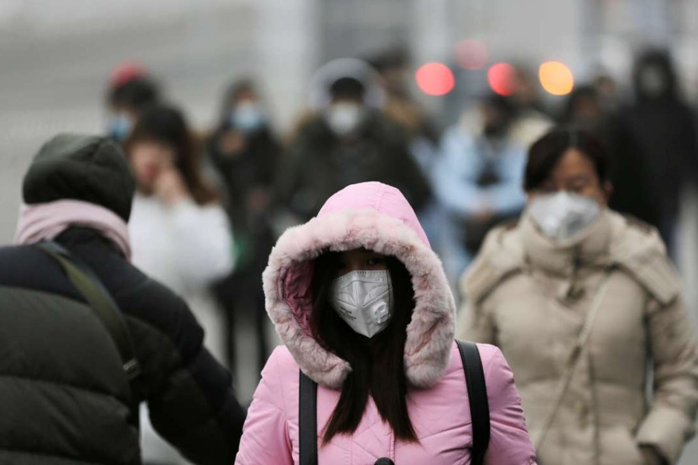 People wearing masks walk towards an office building in Beijing during heavy smog on Wednesday. Photo: Reuters
