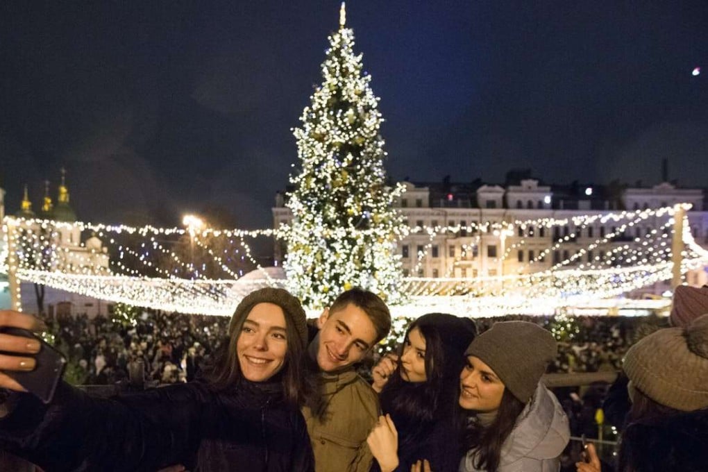 They’re having a great time now, but let’s chack back on them next week. Ukrainians take a selfie as they attend a Christmas tree lighting ceremony in front of the Saint Sophia's Cathedral in Kiev. Photo: EPA