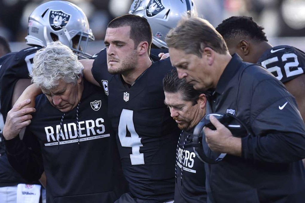 Oakland Raiders quarterback Derek Carr is assisted off the field after sustaining an injury after being tackled by the Indianapolis Colts' Trent Cole. Photo: TNS