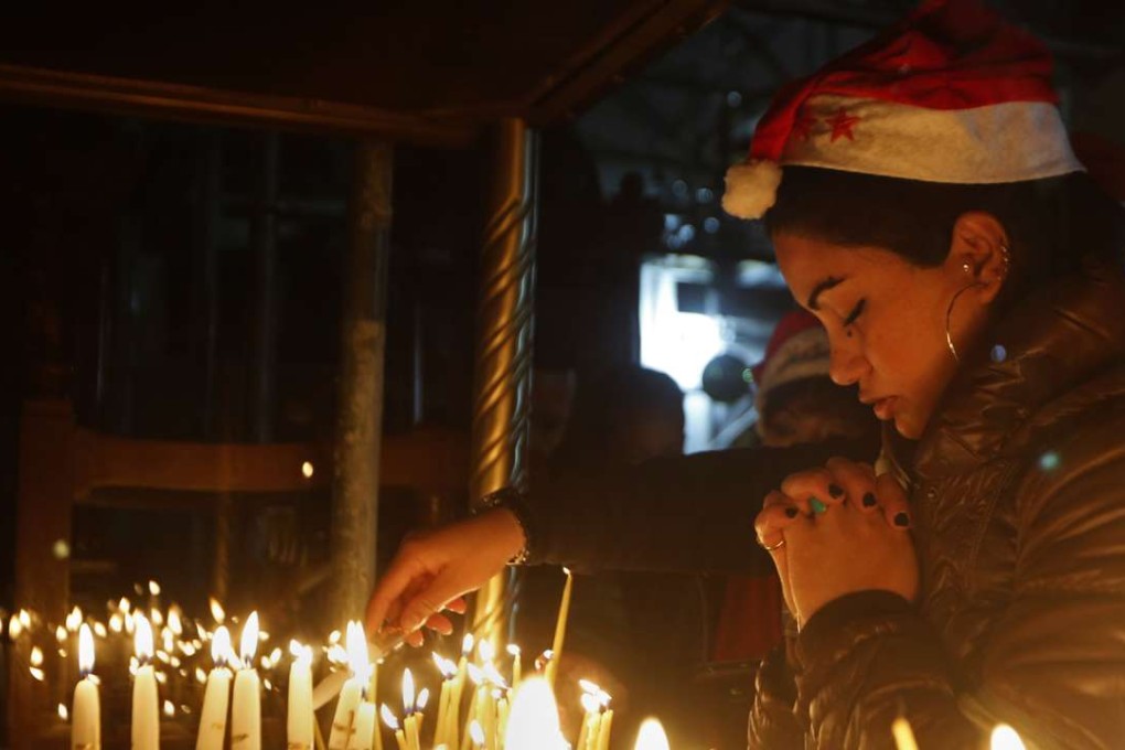 A Christian worshipper prays after lighting a candle on Christmas Eve at the Church of the Nativity. Photo: AP
