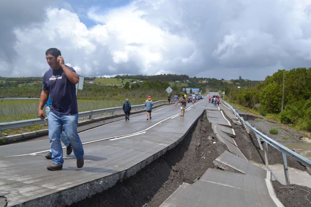 People walk on a highway damaged by an earthquake in Chiloe province, Chile, Sunday. Photo: Xinhua