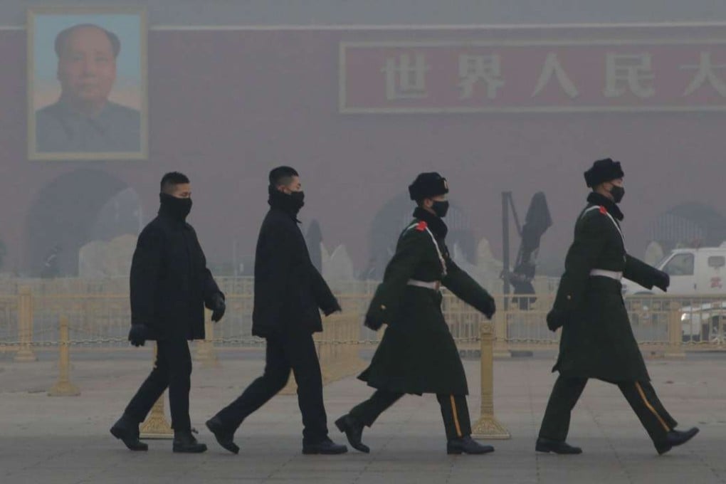 Paramilitary police officers and security personnel wearing masks patrol at Tiananmen Square amid a red alert for heavy air pollution in Beijing, on December 20. Photo: Reuters