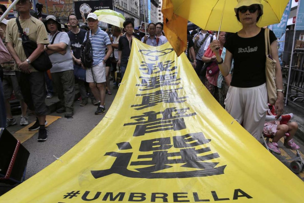 Protesters carry a banner with Chinese words "I want genuine universal suffrage" as they march down a main street during an annual pro-democracy protest in Hong Kong. Photo: AP