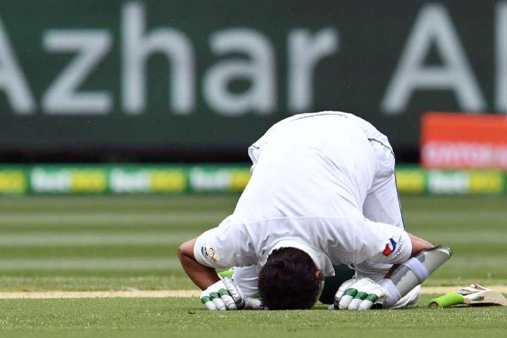 Pakistan batsman Azhar Ali celebrates his century by kissing the grass at the Melbourne Cricket Ground. Photo: AFP