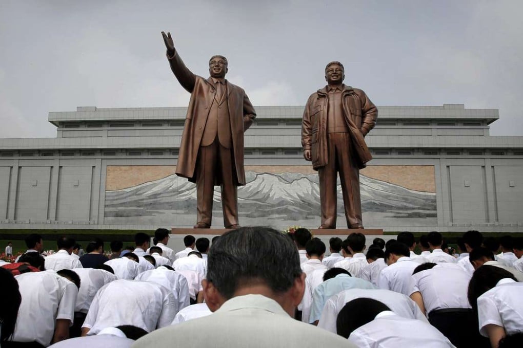 North Koreans bow in front of bronze statues of the late leaders Kim Il-sung, left, and Kim Jong-il at Munsu Hill in Pyongyang. File photo: AP