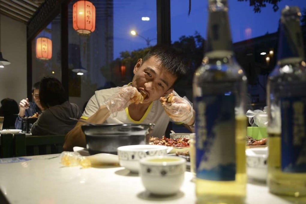 A diner tucking into a rabbit’s head at a restaurant in Chengdu. Photo: AFP