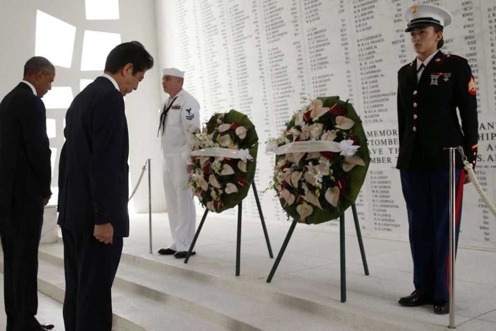 Japanese Prime Minister Shinzo Abe and U.S. President Barack Obama bow their heads during a wreath-laying ceremony aboard the USS Arizona Memorial at Pearl Harbour, Hawaii. Photo: Reuters