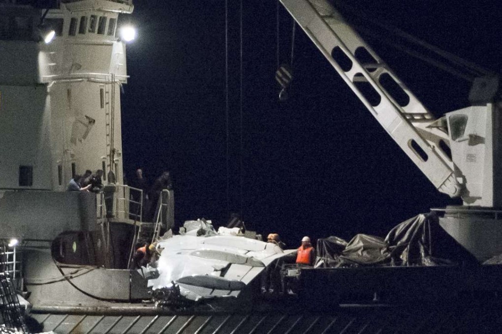 Russian Emergency Ministry employees lift a fragment of a downed military plane out of the Black Sea, outside Sochi on Tuesday. Photo: AP