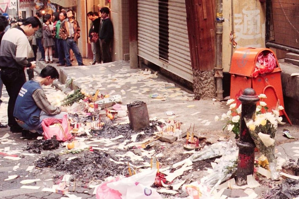 Relatives perform peace rituals for the deceased in Lan Kwai Fong.
