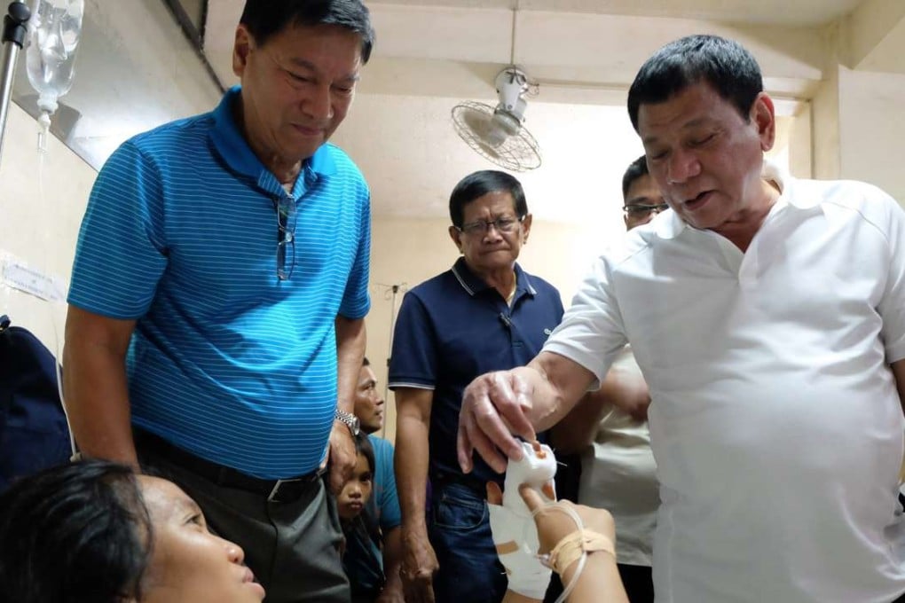 President Rodrigo Duterte visitis a bombing victim who was wounded in a Christmas eve grenade attack in the town of Midsayap, North Cotabato province. Photo: EPA