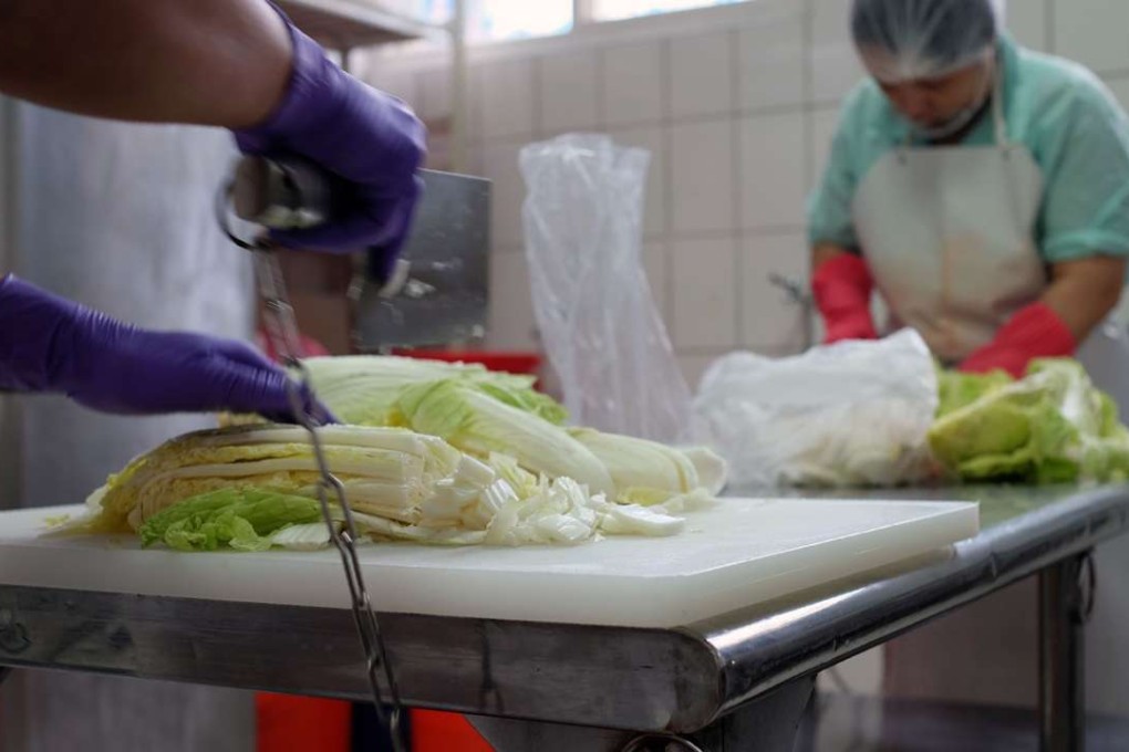 Inmates cut cabbage to make kimchi at a correctional facility in Taoyuan, northern Taiwan. The additive-free delicacies made by inmates have gained a loyal public following, and generate hundreds of millions of dollars each year. Photo: AFP