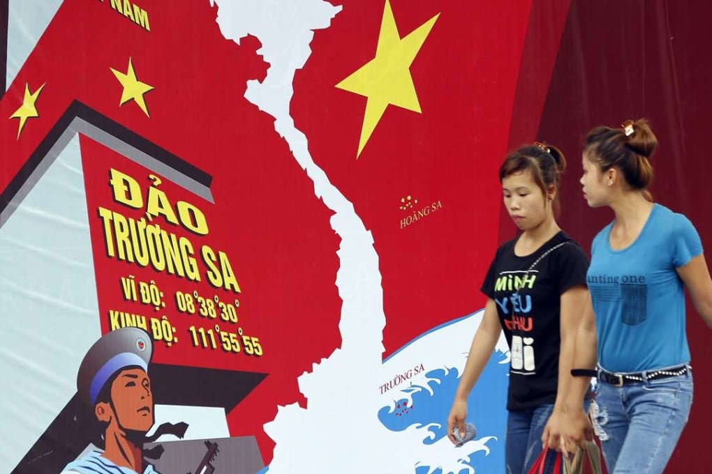 Two women pass a board featuring a map of Vietnam and the words 'Spratly Islands' in a street in Hanoi, Vietnam. Diplomatic disputes between China and Vietnam have prompted resentment of Chinese tourists in the country. Photo: EPA