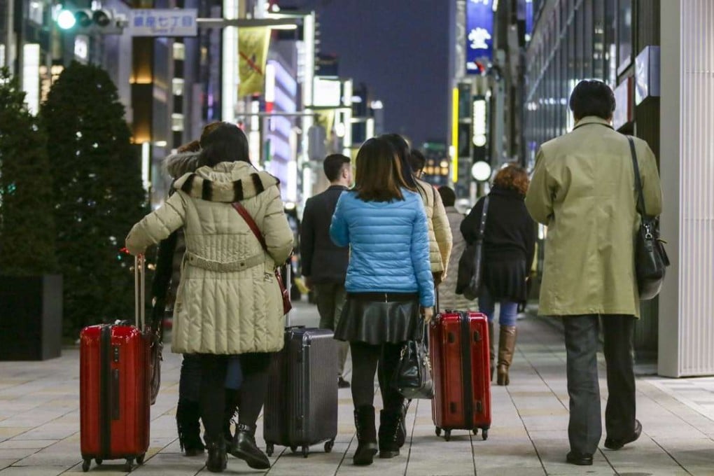 Chinese tourists carry suitcases packed with purchases after bulk buying, or ‘Bakugai’ in central Tokyo. Chinese tourists' shopping makes a large contribution to the Japanese economy. Photo: EPA