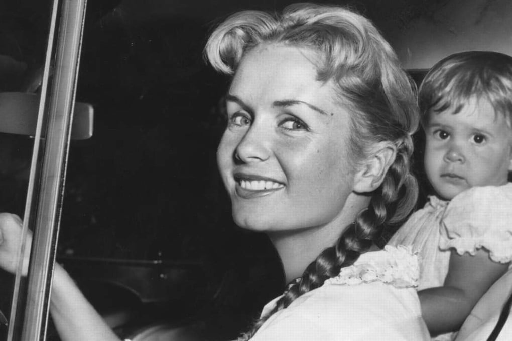 Debbie Reynolds with her daughter Carrie Fisher, 23 months old, smiles as she leaves the house on September 9, 1958, to visit friends. Reynolds died on Wednesday, one day after Fisher. Photo: TNS