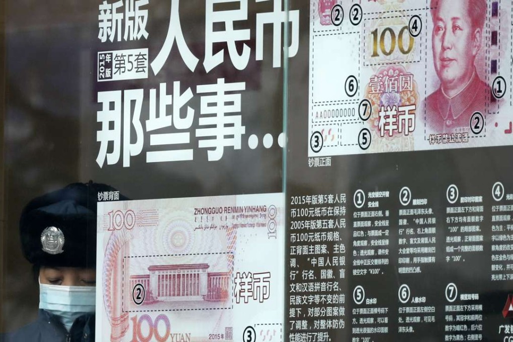 A security guard takes a rest near a bank window panel displaying security markers on the latest yuan note in Beijing. Photo: AP