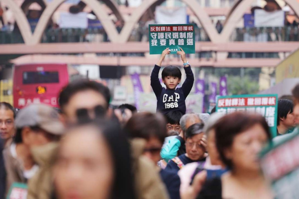 A child holds up a placard during the march on Sunday. Photo: Felix Wong