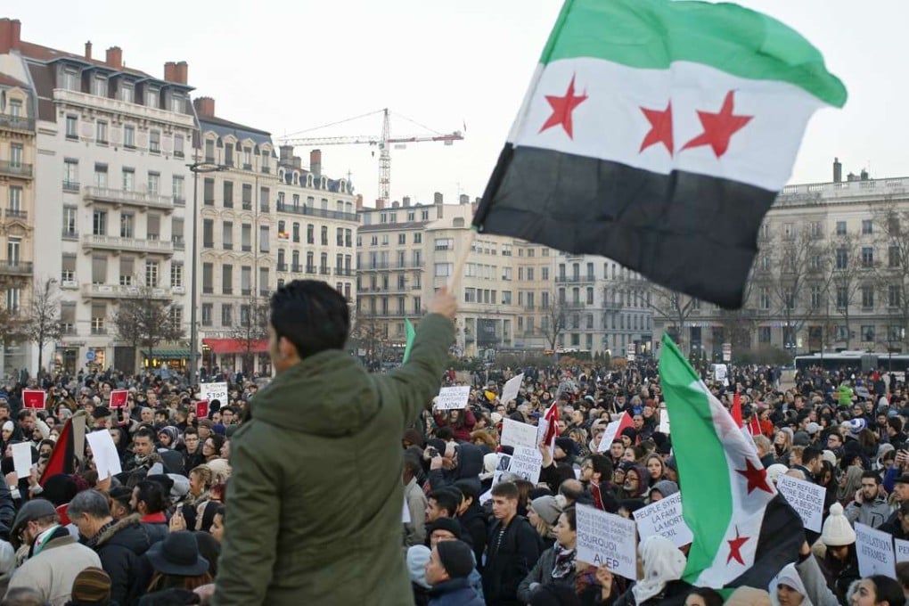 Demonstrators in Lyon, France, wave Syrian flags as they protest against the war and the humanitarian crisis in Aleppo, on December 17. Photo: AP
