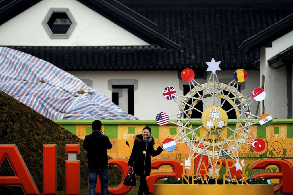 A visitor poses for photo outside the Alibaba headquarters in Hangzhou in east China's Zhejiang province. Photo: AP