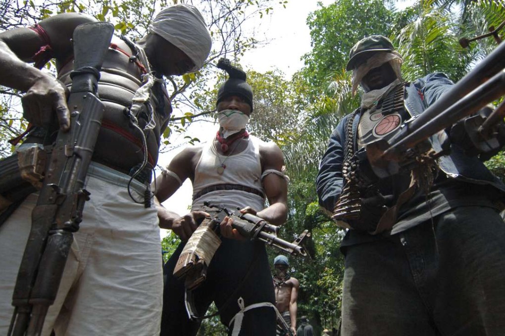 Masked Ateke Tom militants stand with guns at their camp, in Okrika, Rivers State, Nigeria. Picture: AFP