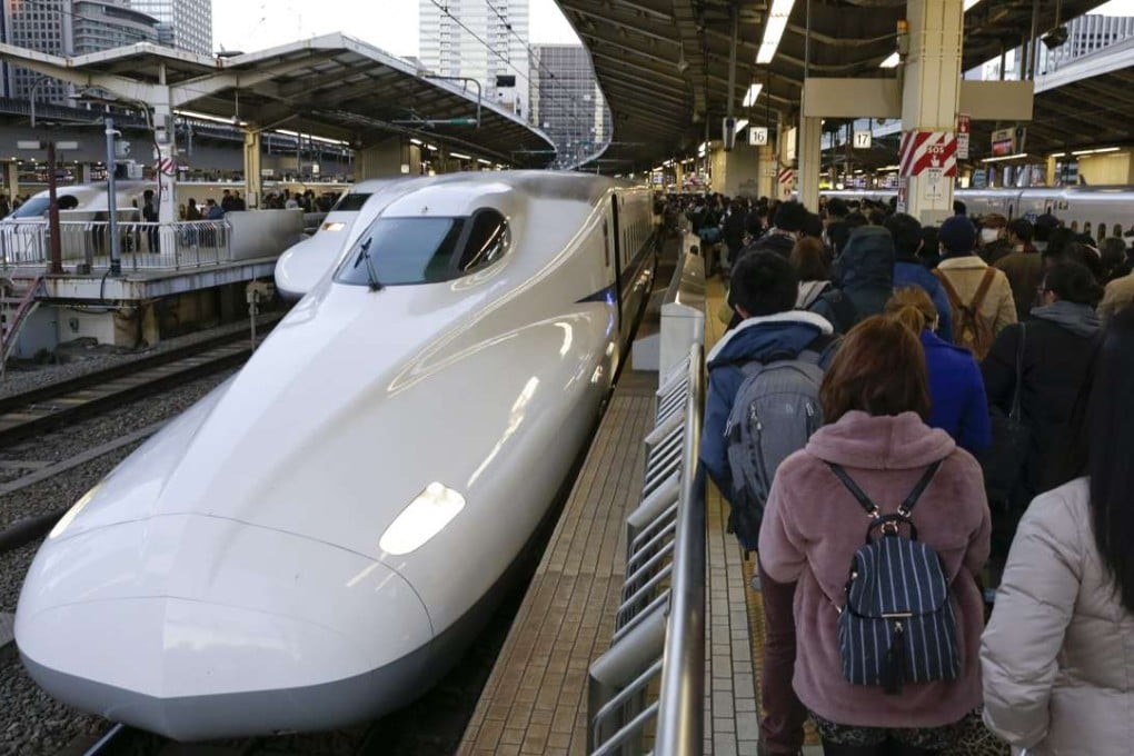 Passengers queue to board the Shinkansen bullet train at Tokyo railway station. Photo: EPA