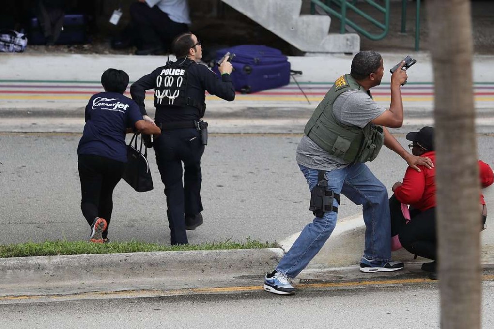 Police assist people seeking cover outside Terminal 2 of Fort Lauderdale-Hollywood International airport after a shooting. Photo: AFP