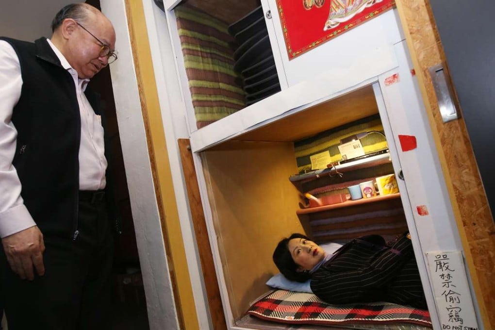 Chief executive hopeful Regina Ip tries out a ‘coffin cubicle’ as rival Woo Kwok-hing looks on. Photo: David Wong