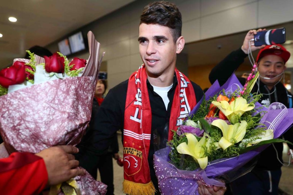 Brazilian football player Oscar receives flowers as he arrives at Shanghai airport on January 2. Photo: AFP