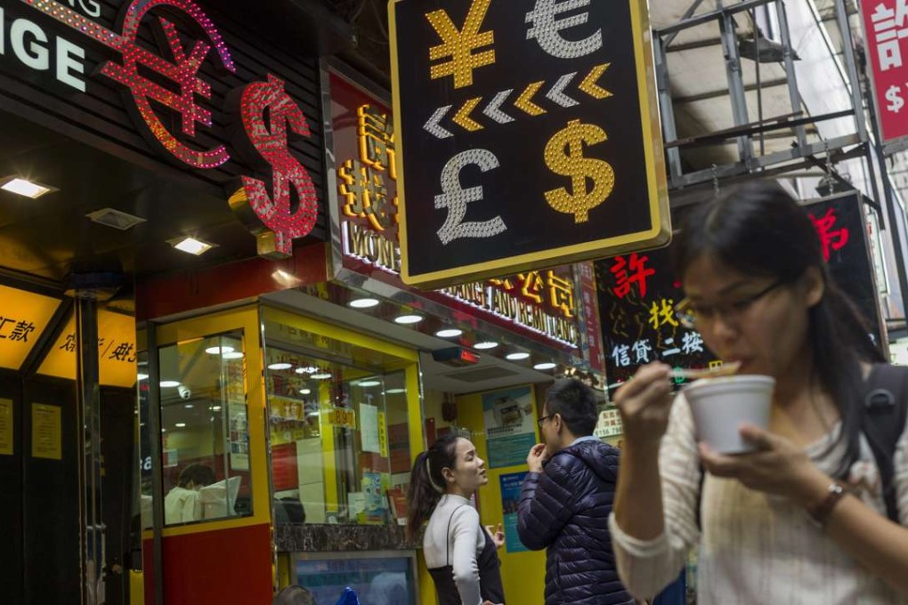 A woman eats instant noodles next to a currency exchange shop in Causeway Bay. Over the past decade, the average income of Hong Kong’s white-collar workers has remained largely unchanged while living costs have surged. As a result, their standard of living has declined. Photo: EPA