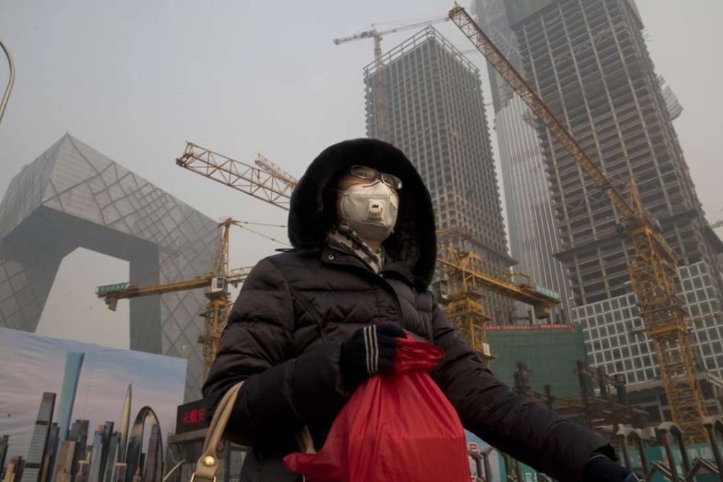 A woman braves the smog in the centre of Beijing on Friday. Photo: AP