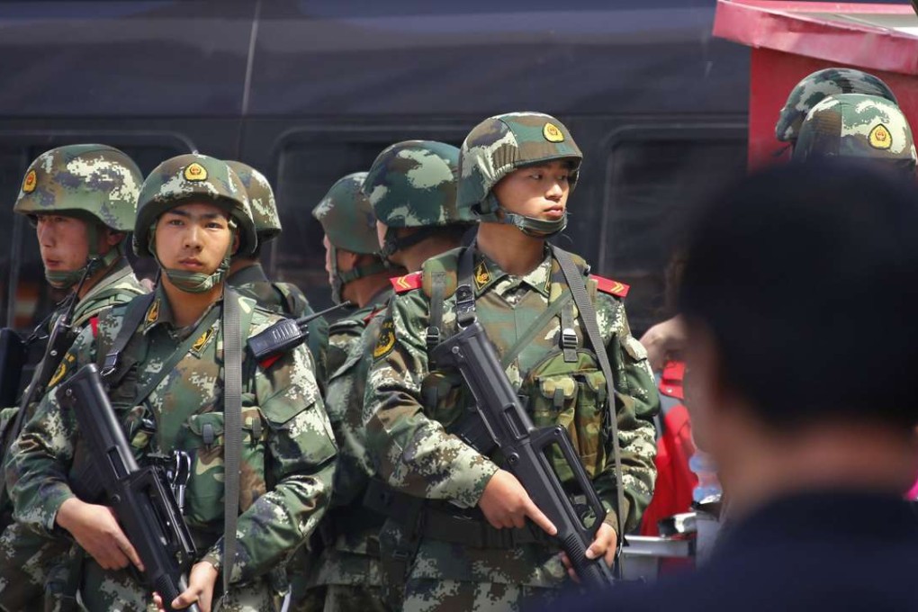 A file picture of paramilitary policemen standing guard at a railway station in Urumqi in Xinjiang. Photo: Reuters