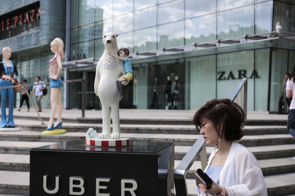 A woman walks past an Uber station outside a shopping mall in Beijing. Photo: AP