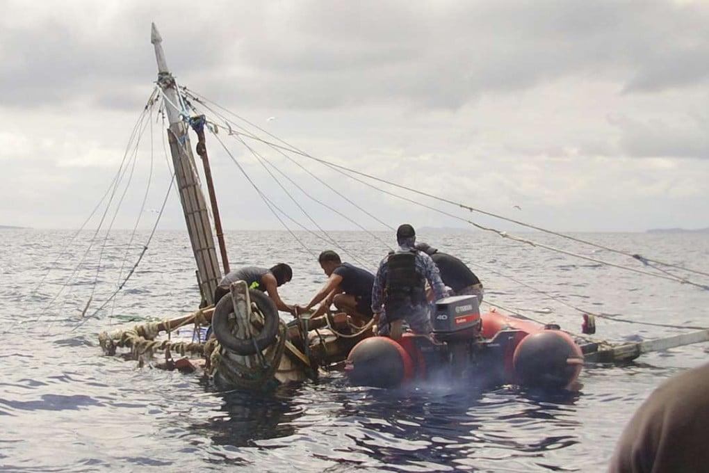 Members of the Philippine Coast Guard inspect the almost sunken fishing boat of Filipino fishermen who were killed n waters near Zamboanga City, southern Philippines. Photo: AP