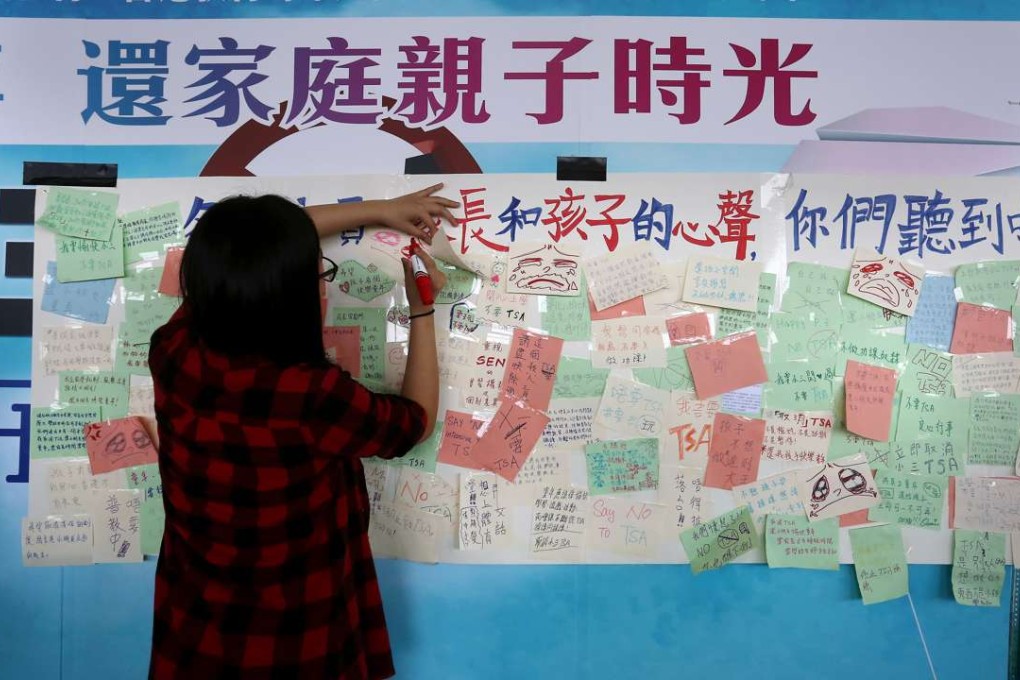A woman writes on a message board put up by activists protesting against the TSA, outside the Legislative Council building in Tamar, in November 2015. Photo: Jonathan Wong