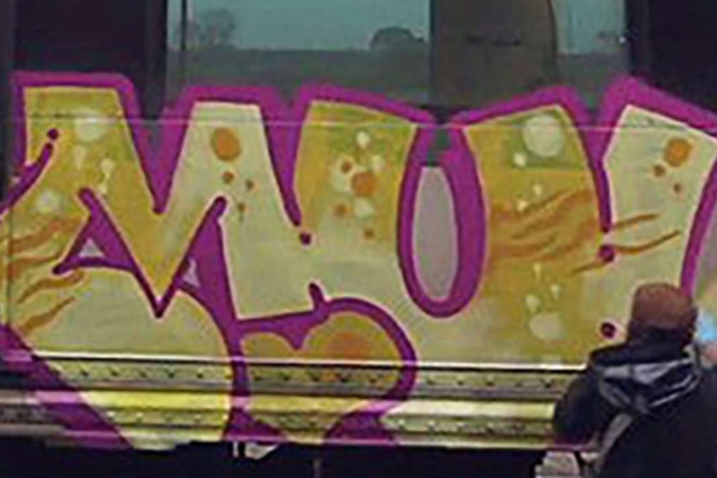 An image taken from the video showing one of the vandals spraying paint on a subway carriage. Photo: Handout