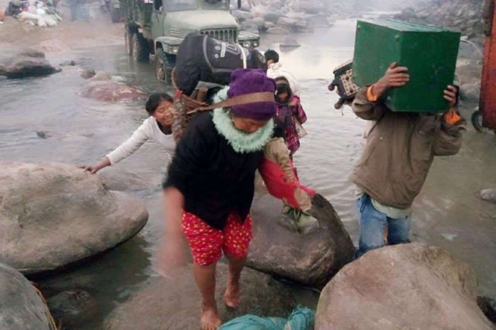 Myanmese residents displaced by fighting between militias and military troops arrive to cross the river boundary between Myanmar and China near China's Yunnan province. Photo: AFP