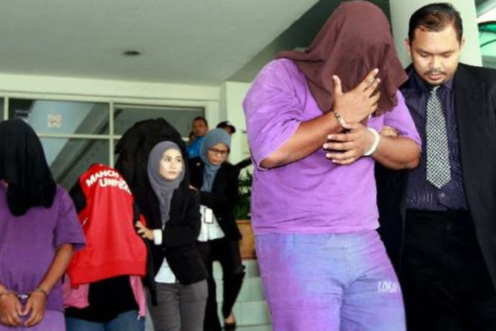 Malaysian Anti-Corruption Commission officers escorting four immigration officers out from the Shah Alam magistrate’s court after they were remanded for six days. Photo: KK SHAM/The Star