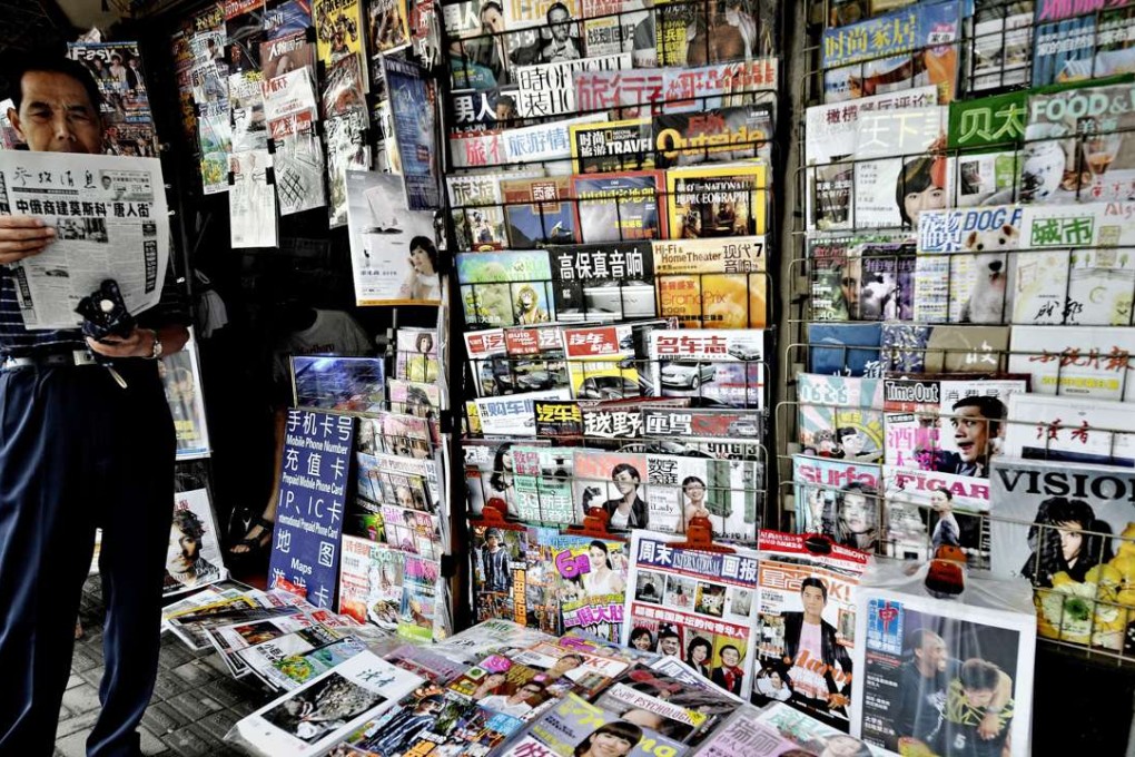A man reads the news at a newspaper stall in Shanghai. Photo: AFP