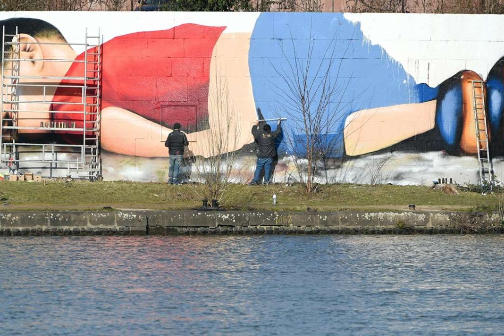 rtist Justus Becker and Oguz Sen paint a mural featuring drowned Syrian refugee boy Aylan Kurdi in Frankfurt am Main. The mural replicates the photograph of tiny Aylan's lifeless body on a beach after he drowned on the crossing to Greece. Photo: AFP