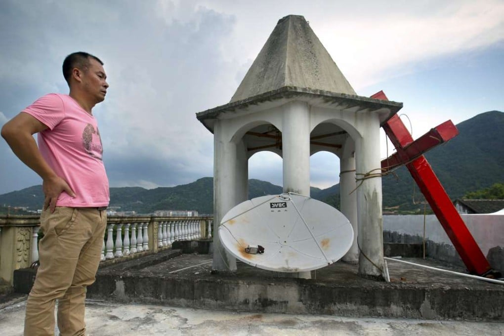 Lay Chinese church leader Tu Shouzhe stands on his Protestant church's roof hours after government cut down the building's cross, in Pingyang county, Zhejiang province in 2015. Photo: AP