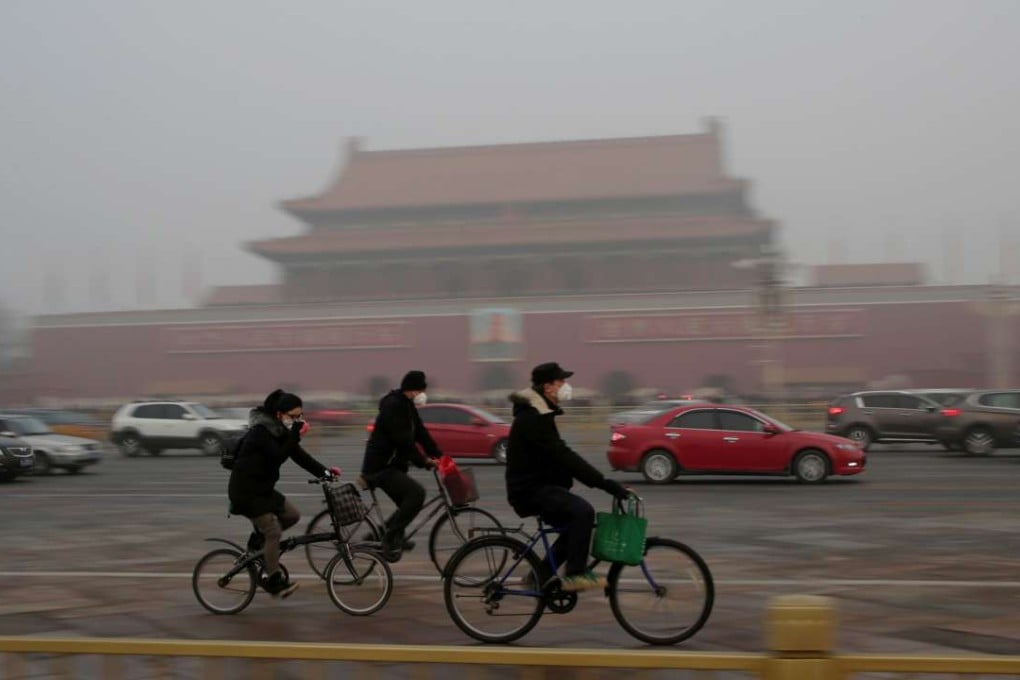 Cyclist wearing masks pass Beijing’s Tiananmen Square in heavy smog on December 20. Photo: Reuters